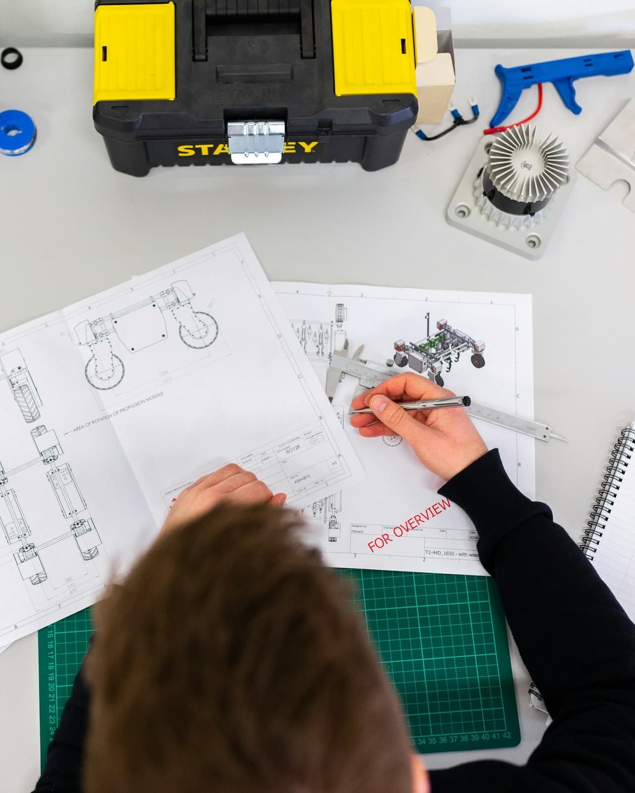 Engineer checking a technical drawing against measurements before sign-off